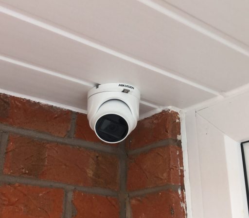 A camera mounted on the side of a brick wall.