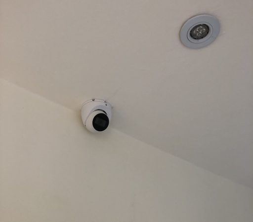 A camera mounted on the ceiling of a room.